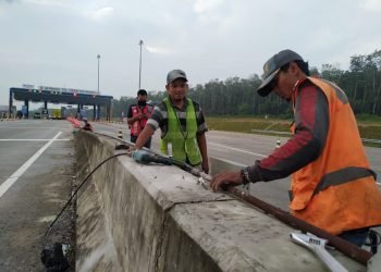 PERAWATAN. Pekerja PT Waskita Karya merawat berkala kabel optik di depan pintu gerbang tol Itera Kotabaru, Lampung Selatan, Kamis (18/6).
n LAMPUNG POST/SUKISNO