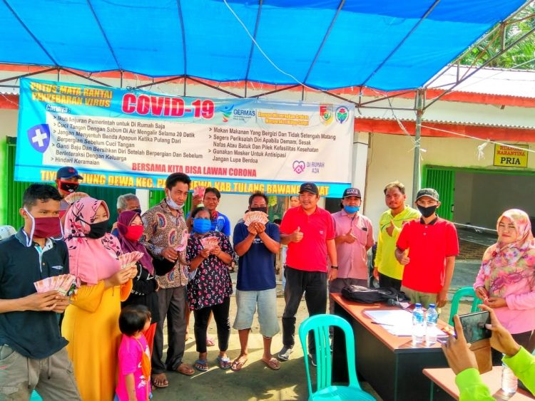 TERIMA BANTUAN. Warga terdampak Covid-19 di Tiyuh Bujungdewa menerima bantuan BLT-DD tahap kedua, Jumat (5/6). LAMPUNG POST/AHMAD SOBIRIN