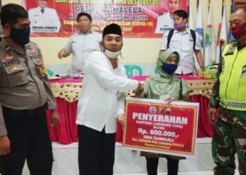 BERI BANTUAN. Kepala Desa Tajimalela, Sahrul Efendi, memberikan BLT DD kepada warga di Desa Tajimalela, Kecamatan Kalianda, Lampung Selatan. LAMPUNG POST/AAN KRIDOLAKSONO