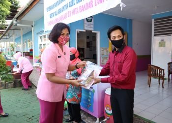 SERAHKAN BANTUAN. Ketua Pengurus Yayasan Kemala Bhayangkari Daerah Lampung, Sarie Purwadi Arianto, memberikan bantuan untuk guru dan Karyawan, di TK Kemala Bhayangkari 23 Kota Bandar Lampung, Kamis (25/6) pagi. IST