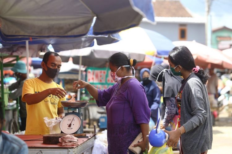 PROTOKOL KESEHATAN. Pedagang dan pembeli bertransaksi di Pasar Tugu Bandar Lampung dengan tetap menerapkan protokol kesehatan, di antaranya memakai masker, Selasa (16/6). Sejumlah pasar di Lampung juga dihimbau untuk menerapkan protokol kesehatan saat new normal. n LAMPUNG POST/ZAINUDDIN