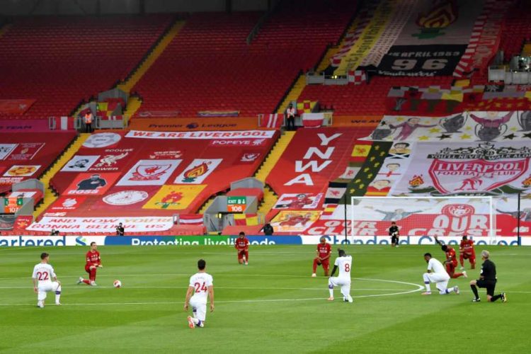 BERLUTUT SEBELUM BERTANDING. Para pemain berlutut sebelum memulai pertandingan sepak bola Liga Primer Inggris antara Liverpool dan Crystal Palace di Anfield di Liverpool, Kamis (24/6). Pada pertandingan tersebut Liverpool menang 4-0 atas Crystal Palace. n AFP/Paul ELLIS