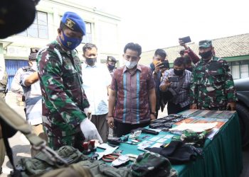 LETKOL TNI GADUNGAN DITANGKAP. Komandan Denpomdam II/3 Lampung Mayor CPM Hanri Wira Kusuma (kiri) bersama Kasat Reskrim Polresta Bandar Lampung Kompol Resky Maulana (kedua kiri) memeriksa sejumlah barang bukti milik TH yang mengaku sebagai anggota TNI berpangkat letnan kolonel di kantor Denpomdam II/3 Lampung, Lampung, Jumat (24/7). Anggota Denpom II/3 menangkap anggota TNI gadungan tersebut atas laporan warga dan berhasil mengamankan barang bukti berupa 1 buah KTA Gartab I/Jakarta, 2 pucuk air soft gun, mobil dinas palsu beserta 1 pasang pelat dinas TNI AD.
LAMPUNG POST/ZAINUDDIN