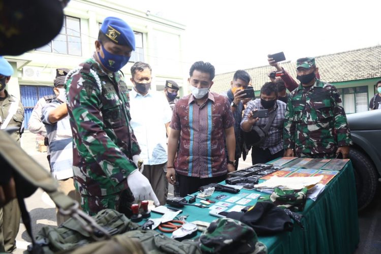 LETKOL TNI GADUNGAN DITANGKAP. Komandan Denpomdam II/3 Lampung Mayor CPM Hanri Wira Kusuma (kiri) bersama Kasat Reskrim Polresta Bandar Lampung Kompol Resky Maulana (kedua kiri) memeriksa sejumlah barang bukti milik TH yang mengaku sebagai anggota TNI berpangkat letnan kolonel di kantor Denpomdam II/3 Lampung, Lampung, Jumat (24/7). Anggota Denpom II/3 menangkap anggota TNI gadungan tersebut atas laporan warga dan berhasil mengamankan barang bukti berupa 1 buah KTA Gartab I/Jakarta, 2 pucuk air soft gun, mobil dinas palsu beserta 1 pasang pelat dinas TNI AD.
LAMPUNG POST/ZAINUDDIN