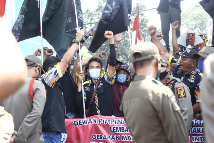 TOLAK RUU HIP. Gerakan Masyarakat Bawah Indonesia berorasi di depan gerbang Kantor DPRD Provinsi Lampung, Rabu (8/7). Massa aksi ini menyatakan sikap menolak serta mendesak Pemerintah Pusat untuk DPR menghentikan proses legislasi pembahasan proses Undang-Undang Haluan Ideologi Pancasila (RUU HIP), Rabu (8/7).
LAMPUNG POST/ZAINUDDIN