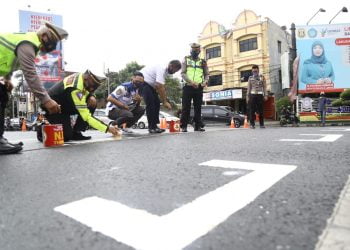 RUANG HENTI KHUSUS. Satuan Lalu Lintas Polresta Bandar Lampung bersama Dinas Perhubungan Kota Bandar Lampung membuat ruang henti khusus (RHK) kendaraan bermotor di area lampu lalu lintas Tugu Adipura Bandar Lampung, Jumat (17/7). Polresta Bandar Lampung dan Dinas Perhubungan Kota Bandar Lampung memberikan tanda jarak di persimpangan tersebut untuk membatasi jarak antarpengendara guna mencegah penyebaran Covid-19.
LAMPUNG POST/ZAINUDDIN