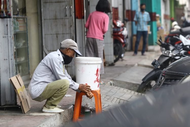 PROTOKOL KESEHATAN. Seorang warga sedang mencuci tangan yang disiapkan di depan toko di Jalan Hayam Wuruk, Bandar Lampung, Selasa (21/7). Sanksi tegas pelanggar protokol kesehatan diberlakukan untuk masyarakat dan pemilik tempat-tempat usaha yang abai. Apalagi kini masih banyak pemilik tempat usaha yang tidak menyiapkan tempat cuci tangan, sabun, dan hand sanitizer.
LAMPUNG POST/ZAINUDDIN