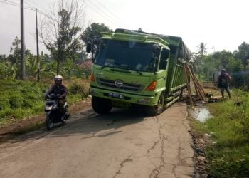 AMBLES. Truk Fuso bermuatan jagung ambles di ruas jalan Simpang Palas—Bandanhurip, Kecamatan Palas, Senin (20/7). LAMPUNG POST/ARMANSYAH