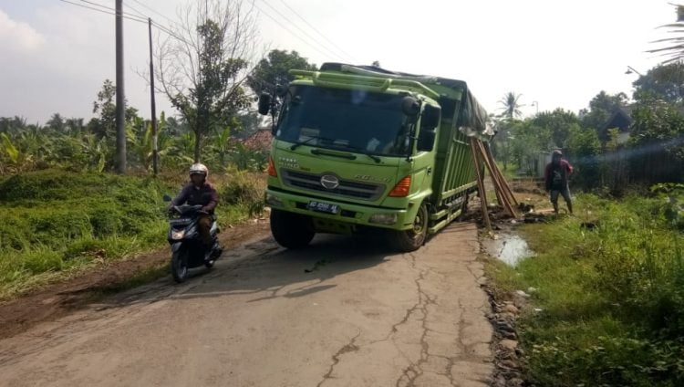 AMBLES. Truk Fuso bermuatan jagung ambles di ruas jalan Simpang Palas—Bandanhurip, Kecamatan Palas, Senin (20/7). LAMPUNG POST/ARMANSYAH