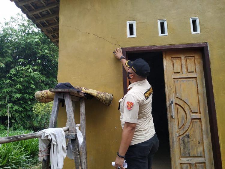 RUMAH RUSAK. Petugas terlihat mengecek rumah warga yang rusak akibat peledakan batu, Rabu (22/7). n DOK WARGA