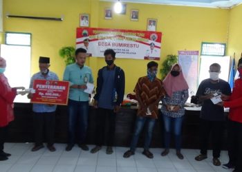 SERAHKAN BLT. Kepala Desa Bumirestu, Kecamatan Palas, Lampung Selatan, Sukiman, bersama Camat Palas Rika Wati menyerahkan BLT DD tahap kedua secara simbolis, di kantor desa setempat, Minggu (12/7). LAMPUNG POST/ARMANSYAH