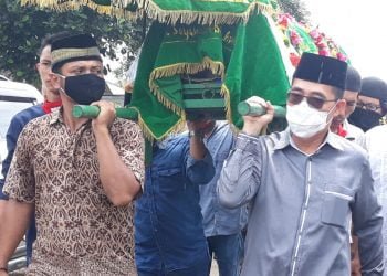GOTONG KERANDA. Bupati Lamtim Zaiful Bokhari ikut menggotong keranda jenazah mantan Bupati Lampung Timur Erwin Arifin menuju liang lahat, Kamis (16/7). LAMPUNG POST/DJONI HARTAWAN JAYA