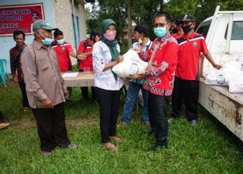 Kepala Diskominfo Lamsel M. Sefri Masdian tengah menyerahkan sembako kepada Kepala Desa di Kecamatan Candipuro, Jumat, 3 Juli 2020.  Foto. Dok. Diskomonfo Lamsel