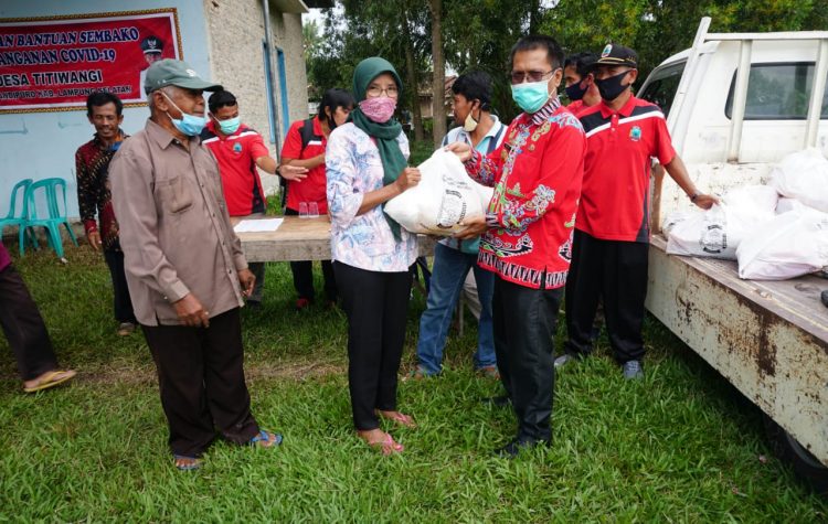 Kepala Diskominfo Lamsel M. Sefri Masdian tengah menyerahkan sembako kepada Kepala Desa di Kecamatan Candipuro, Jumat, 3 Juli 2020.  Foto. Dok. Diskomonfo Lamsel