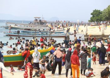 WISATAWAN ABAIKAN PROTOKOL KESEHATAN. Warga memadati lokasi Pantai Mutun, Pesawaran, saat menghabiskan liburan pasca-Hari Raya Iduladha 1441 H, Minggu (2/8). Kebijakan new normal pandemi Covid-19 seharusnya disikapi masyarakat dengan menerapkan protokol kesehatan saat beraktivitas di luar namun para wisatawan mengabaikan protokol kesehatan saat sektor pariwisata di Lampung mulai bangkit sejak era new normal.
LAMPUNG POST/ZAINUDDIN