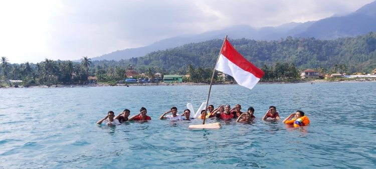 KIBARKAN DI LAUT. Para pemuda asal Desa Sukaraja, Kecamatan Rajabasa, Lampung Selatan, saat upacara pengibaran bendera merah putih di tengah laut, desa setempat, Senin (17/8/). LAMPUNG POST/ARMANSYAH