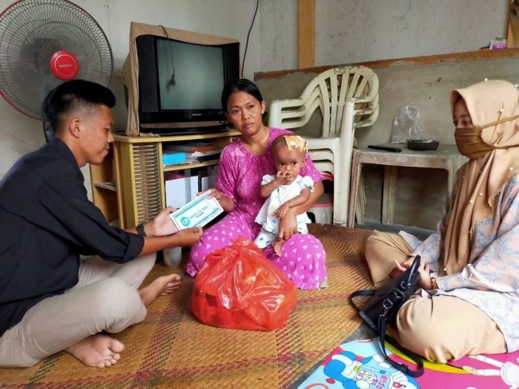 TALI ASIH. Komunitas Kita Pemuda (K2P) Desa Bangunan, Kecamatan Palas, Lampung Selatan, memberikan bantuan sembako dan tali asih kepada keluarga bocah penderita hidrosefalus di Dusun Karangmekar, Desa Mekarmulya, Kecamatan Palas, Minggu (2/8). LAMPUNG POST/ARMANSYAH