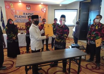 PERBAIKAN DUKUNGAN INDEPENDEN. Ketua KPU Metro Nurris Septa Pratama menyerahkan berkas perbaikan kepada pasangan bakal calon (balon) wali kota dan wakil wali kota Metro Wahdi-Qomaru saat rapat pleno terbuka hasil rekapitulasi perbaikan dukungan bakal calon (balon) wali kota dan wakil wali kota Metro jalur perseorangan atau independen, Kamis (20/8). Saat ini dukungan yang dimiliki Wahdi-Qomaru ada 11.491 artinya pasangan Wahdi-Qomaru telah memenuhi syarat dan dapat mendaftarkan diri ke KPU pada 4 sampai 6 September mendatang. LAMPUNG POST/BAMBANG PAMUNGKAS