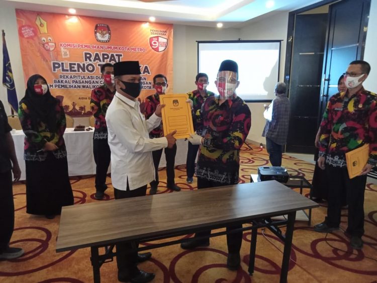 PERBAIKAN DUKUNGAN INDEPENDEN. Ketua KPU Metro Nurris Septa Pratama menyerahkan berkas perbaikan kepada pasangan bakal calon (balon) wali kota dan wakil wali kota Metro Wahdi-Qomaru saat rapat pleno terbuka hasil rekapitulasi perbaikan dukungan bakal calon (balon) wali kota dan wakil wali kota Metro jalur perseorangan atau independen, Kamis (20/8). Saat ini dukungan yang dimiliki Wahdi-Qomaru ada 11.491 artinya pasangan Wahdi-Qomaru telah memenuhi syarat dan dapat mendaftarkan diri ke KPU pada 4 sampai 6 September mendatang. LAMPUNG POST/BAMBANG PAMUNGKAS