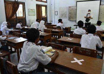 UJI COBA PEMBELAJARAN TATAP MUKA: Guru memberikan materi pelajaran saat uji coba pembelajaran tatap muka di SMAN 1 Pamekasan, Jawa Timur, Rabu (19/8). Pembelajaran tatap muka di tengah Pandemi COVID-19 tersebut, per kelas dibagi menjadi dua kelompok yang dilaksanakan bergantian setiap minggunya. ANTARA FOTO/Saiful Bahri