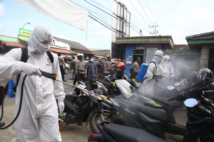 PENYEMPROTAN DISINFEKTAN. Anggota Polda Lampung menyemprotkan cairan disinfektan di Pasar Cimeng, Telukbetung Bandar Lampung, Jumat (25/9). Kasus Covid-19 terus melonjak setiap harinya. Khusus di Lampung, selama September ini saja terjadi penambahan 419 kasus baru.
LAMPUNG POST/ZAINUDDIN