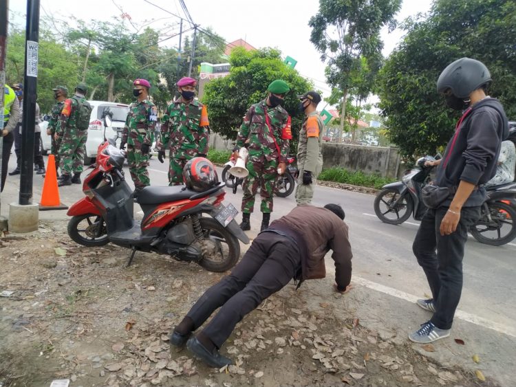 PENULARAN COVID-19 BERTAMBAH. Satuan Tugas Penanganan Covid-19 Kota Bandar Lampung menghukum push up pengendara yang tidak memakai masker di Jalan Pulau Sebesi, Sukarame, Bandar Lampung, Rabu (23/9). Penularan Covid-19 di delapan daerah yang akan melaksanakan Pilkada 9 Desember 2020 terus bertambah. Bahkan, tujuh kabupaten/kota di antaranya sudah berubah status dari zona kuning menjadi oranye.
n LAMPUNG POST/SUKISNO