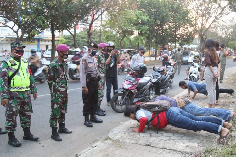 LANGGAR PROTOKOL KESEHATAN. Petugas dari Gugus Tugas Covid-19 Kota Bandar Lampung memberikan hukuman kepada pengendara yang tidak mematuhi protokol kesehatan, salah satunya tidak memakai masker, di jalan jalur dua Sultan Agung, Way Halim, Bandar Lampung, Senin (7/9).
n LAMPUNG POST/SUKISNO