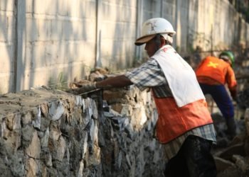 PEMBANGUNAN DRAINASE. Seorang pekerja mengerjakan proyek pembangunan drainase di Jalan Endro Suratmin, Sukarame, Bandar Lampung menuju Sungai Prasasti di dekat Kantor Dinas Pekerjaan Umum Kota Bandar Lampung untuk pencegahan banjir saat musim hujan, Senin (28/9).
n LAMPUNG POST/SUKISNO