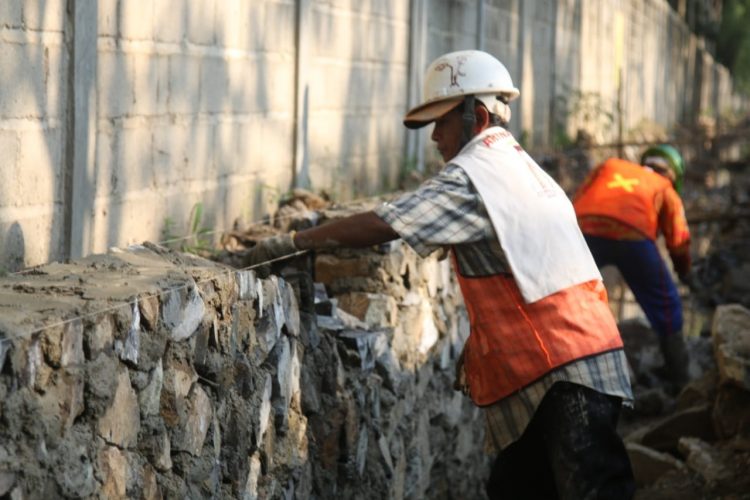 PEMBANGUNAN DRAINASE. Seorang pekerja mengerjakan proyek pembangunan drainase di Jalan Endro Suratmin, Sukarame, Bandar Lampung menuju Sungai Prasasti di dekat Kantor Dinas Pekerjaan Umum Kota Bandar Lampung untuk pencegahan banjir saat musim hujan, Senin (28/9).
n LAMPUNG POST/SUKISNO