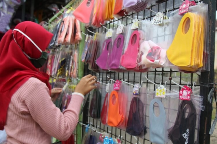 MASKER SKUBA. Penjual masker skuba sedang menata dagangannya di Jalan Sultan Agung, Way Halim, Bandar Lampung, Jumat (18/9). Ikatan Dokter Indonesia (IDI) Kota Bandar Lampung menyatakan masker skuba atau buff ternyata tidak efektif menahan laju penyebaran Covid-19.n LAMPUNG POST/SUKISNO