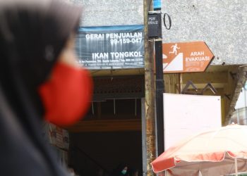 JALUR EVAKUASI. Seorang warga melintas di dekat petunjuk jalur evakuasi saat ada bencana alam di Telukbetung, Bandar Lampung, Selasa (29/9).  Badan Penanggulangan Bencana Daerah (BPBD) Bandar Lampung menargetkan pemasangan petunjuk di 1.500 titik yang difokuskan di empat kecamatan, yaitu Panjang, Bumiwaras, Telukbetung Selatan (TBS), dan Telukbetung Timur (TBT).
LAMPUNG POST/ZAINUDDIN