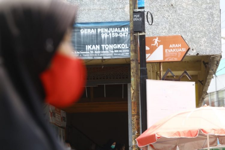 JALUR EVAKUASI. Seorang warga melintas di dekat petunjuk jalur evakuasi saat ada bencana alam di Telukbetung, Bandar Lampung, Selasa (29/9).  Badan Penanggulangan Bencana Daerah (BPBD) Bandar Lampung menargetkan pemasangan petunjuk di 1.500 titik yang difokuskan di empat kecamatan, yaitu Panjang, Bumiwaras, Telukbetung Selatan (TBS), dan Telukbetung Timur (TBT).
LAMPUNG POST/ZAINUDDIN