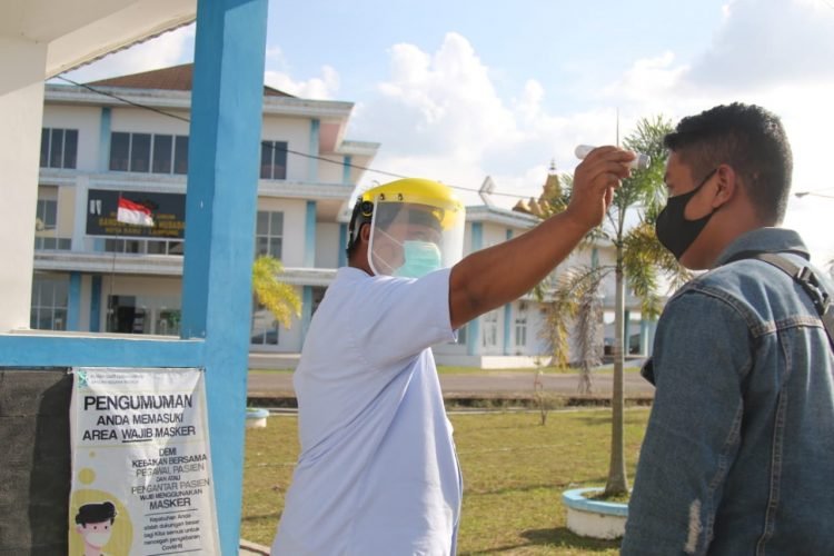 KASUS COVID-19 DI LAMPUNG MENINGKAT. Petugas mengecek suhu tubuh salah satu pengunjung Rumah Sakit Bandar Negara Husada (RSBNH) di Kota Baru yang ditunjuk sebagai rumah sakit pusat penanganan Covid-19 di Lampung, Rabu (9/9). Jumlah kasus Covid-19 di Lampung terus mengalami peningkatan. Bahkan, empat daerah di Lampung; Lampung Utara, Lampung Barat, Pringsewu, dan Bandar Lampung kini berada dalam zona oranye. Perubahan zona dari kuning ke oranye itu lantaran keempat kabupaten/kota ini memiliki risiko kenaikan kasus Covid-19 dengan kategori sedang.
LAMPUNG POST/SUKISNO