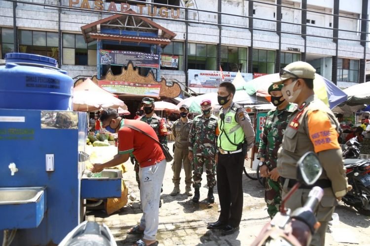 PENERAPAN PROTOKOL KESEAHATAN. Tim Satgas Covid-19 Kota Bandar Lampung terus mengawasi penerapan protokol kesehatan untuk mencegah penyebaran Covid-19  di Pasar Tugu Bandar Lampung, Selasa (15/9).
LAMPUNG POST / ZAINDDUIN