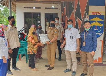 TERIMA BERAS. Keluarga penerima manfaat (KPM) menerima bantuan beras yang diberikan oleh Dinas Sosial Kota Metro, Kamis (24/9). n LAMPUNG POST/BAMBANG PAMUNGKAS