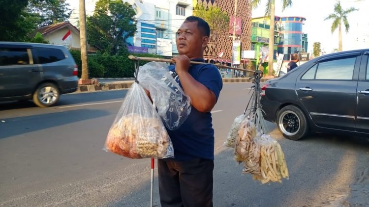 BERALIH DAGANG KERUPUK. Rudi, tukang pijat tunanetra yang beralih profesi menjadi dagang kerupuk keliling akibat efek pandemi Covid-19, Selasa (8/9). Ia mulai berkeliling dari jam satu siang atau setengah dua mulai dari daerah Pondok Pesantren Kalimosodo, Kemiling, menuju Jalan Pagar Alam dilanjutkan ke Zainal Abidin Pagaralam ke arah Pramuka, Bandar Lampung.
LAMPUNG POST/ATIKA OKTARIA