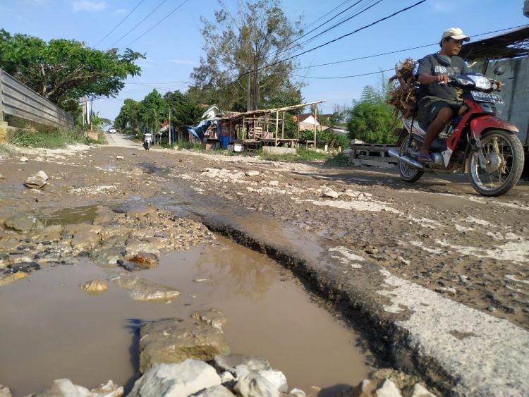 JALAN RUSAK. Seorang pengendara melintasi jalan rusak di Jalan Pulau Singkep, Sukarame Baru, Bandar Lampung, Minggu (4/10). Jalan tersebut dikeluhkan masyarakat sekitar karena ketika musim hujan, kondisi jalan berlumpur dan licin.
n LAMPUNG POST/SUKISNO