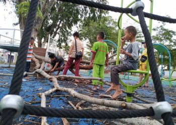 POHON TUMBANG DI ELPHANT PARK. Anak-anak sedang membersihkan puing-puing pohon tumbang di area bermain Elephant Part, Enggal Bandar Lampung, Jumat (2/10). n LAMPUNG POST/SUKISNO