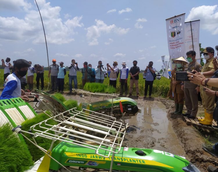 PELUNCURAN KARTU PETANI BERJAYA. Menteri Pertanian Syahrul Yasin Limpo (dua kanan) bersama Gubernur Lampung Arinal Djunaidi (kanan) melihat petani mengoperasikan mesin pemotong padi saat panen raya yang bersamaan dengan peluncuran program Kartu Petani Berjaya (KPB) di Desa Tempuran, Kecamatan Trimurjo, Lampung Tengah, Lampung, Selasa (6/10).
LAMPUNG POST/WAHYU PAMUNGKAS