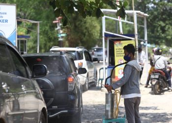 SEMPROTKAN CAIRAN DISINFEKTAN. Petugas menyemprotkan cairan disinfektan ke kendaraan pengunjung dan mengimbau pengunjung untuk mematuhi protokol kesehatan 3M di Pantai Mutun, Pesawaran, Kamis (29/10). Sejumlah tempat wisata pantai di Lampung mulai dipenuhi pengunjung dari luar kota saat libur panjang.
LAMPUNG POST/ZAINUDDIN