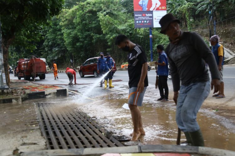ANCAMAN BANJIR. Sejumlah petugas BPBD Kota Bandar Lampung membersihkan sisa lumpur yang terbawa air hujan di Jalan Diponegoro, Selasa (20/10). Pemerintah kabupaten dan kota di Lampung mulai berbenah menghadapi ancaman bencana banjir di wilayahnya pada masa pandemi Covid-19 ini karena BMKG memprediksi cuaca ekstrem di Lampung akan terjadi selama sepekan ke depan dampak fenomena La Nina di Samudera Pasifik.
n LAMPUNG POST/ZAINUDDIN