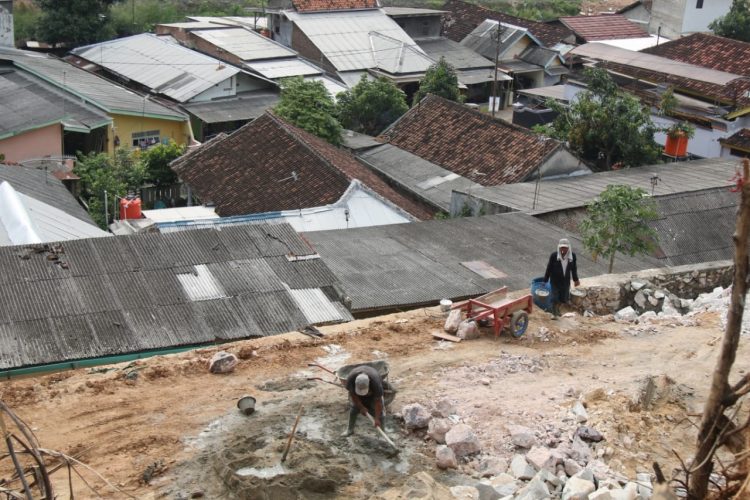 RAWAN BENCANA. Pekerja sedang membuat penahan tanah yang tingginya mencapai atap rumah warga di lokasi pengerukan tanah perbukitan yang akan dijadikan tanah kavelingan di Kelurahan Karangmaritim, Kecamatan Panjang, Bandar Lampung, Selasa (13/10). Daerah tersebut sudah dua kali dilanda banjir lumpur.
n LAMPUNG POST/SUKISNO