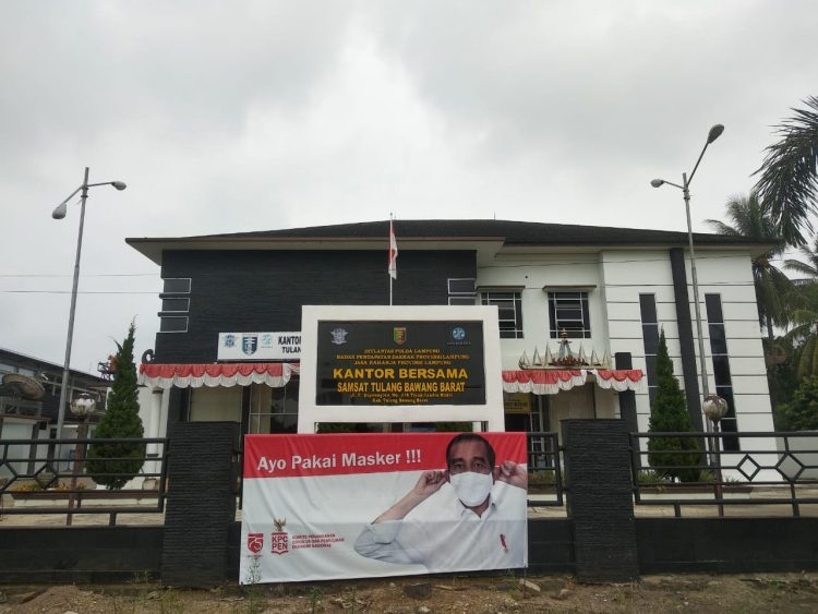POSTER bergambar presiden RI Joko Widodo, menggunakan masker penutup wajah terpasang di pagar kantor Samsat Tulang bawang barat (Tubaba), jalan raya Candra Mukti, dengan tulisan himbauan "Ayo pakai masker ".