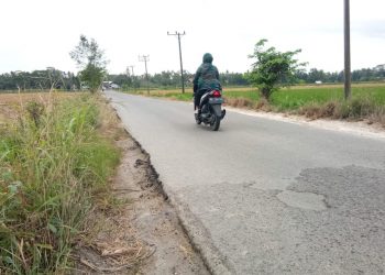 JALAN POROS. Pengendara sepeda motor melintasi ruas jalan poros Kecamatan Sragi, Lamsel, tepat di Desa Baktirasa, Jumat (23/10). n LAMPUNG POST/ARMANSYAH
