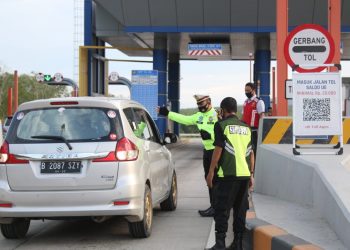 ARUS BALIK. Personel PJR Induk 02 Tol Itera Kotabaru membantu mengarahkan pengguna jalan yang hendak memasuki pintu tol Kotabaru, Lampung Selatan, pada arus balik libur Maulid Nabi Muhammad saw 2020, Minggu (1/11).
n LAMPUNG POST/SUKISNO