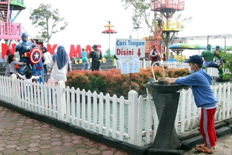 Seorang pengunjung menerapkan protokol kesehatan 3M dengan mencuci tangan saat akan memasuki kawasan wisata Puncak Mas di Sukadaham, Bandar Lampung, Jumat (18/12).
LAMPUNG POST/SUKISNO