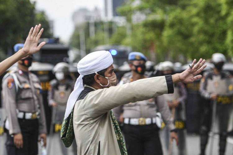 POLISI BUBARKAN MASSA AKSI DEMONSTRASI 1812. Seorang pengunjuk rasa aksi demonstrasi 1812 berusaha menghalau rekannya, di kawasan Medan Merdeka Selatan, Jakarta, Jumat (18/12). Kepolisian membubarkan paksa massa aksi demonstrasi dikarenakan angka penyebaran Covid-19 masih tinggi di wilayah Jakarta.
n ANTARA/M RISYAL HIDAYAT