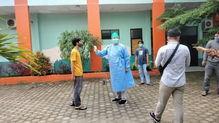 Satu persatu, warga hasil tracing yang akan mengikuti rapid test memasuki Puskesmas Rawat Inap Sidomulyo, Lampung Selatan diukur suhu, Selasa (22/12).