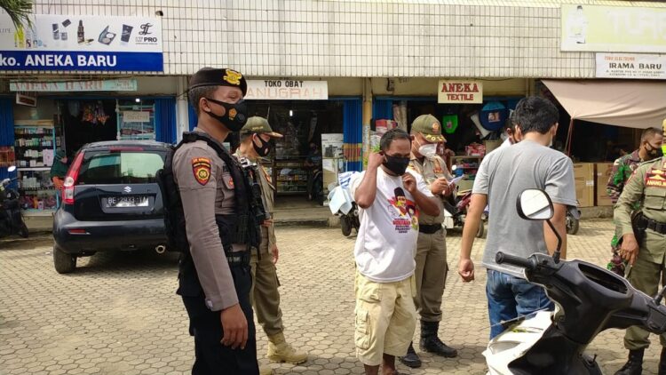 RAZIA MASKER. Polres Lampung Utara bersama Tim Gugus Tugas Covid-19 Lampung Utara melakukan razia masker di Pasar Dekon, Kotabumi, Selasa (5/1). Penyebaran Covid-19 di Lampung Utara cukup tinggi. Bahkan, saat ini Lampura berstatus zona oranye.
LAMPUNG POST/HARI SUPRIYONO