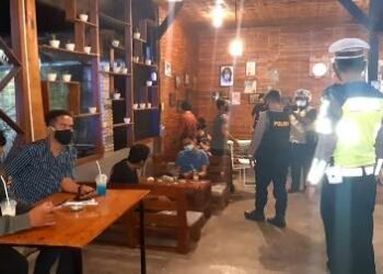 RAZIA. Anggota Polres Pringsewu menggelar razia yustisi di sejumlah kafe dan tempat hiburan di Pringsewu untuk mencegah kerumuman yang dapat menyebarkan Covid-19, Sabtu (23/1).  (LAMPUNG POST/WIDODO)